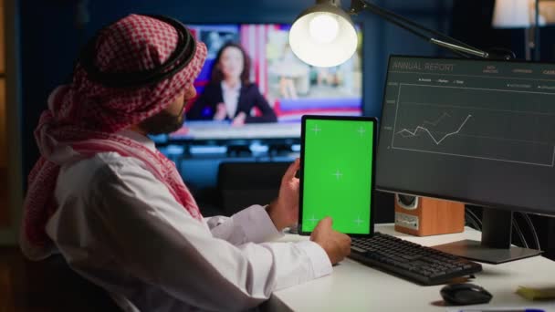 在家的远程工作者一边拿着彩色按键平板电脑 一边在电脑上查看企业年度报告图表 阿拉伯自由职业者 手头拿着模拟数字设备执行公司任务 — 图库视频影像