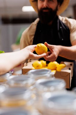 Sıfır atık dükkanındaki müşteri dükkan sahibiyle konuşuyor. Yeni toplanmış organik meyveler hakkında sorular soruyor. Çevre dostu bir müşteri eco mağazasında doğal ürünler soruyor.