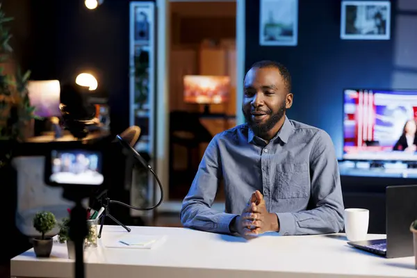 African american streamer doing live broadcast talking to audience about recent news headlines. Internet show host talking with viewers, presenting information in entertaining manner