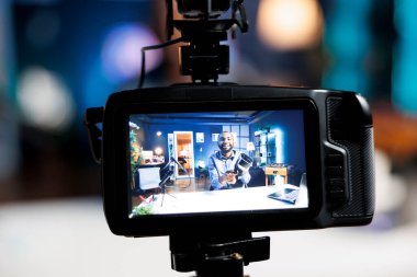 Çevrimiçi izleyiciler için sanal gerçeklik ürünü değerlendirmesi çeken, video mühendislerinin bulanık arkaplandaki görüntülerini yakalamak için kullanılan profesyonel video prodüksiyon kamerasına odaklanın.