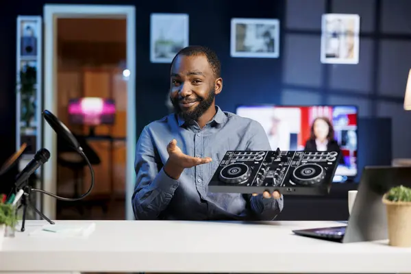 Internet show host being sponsored by partnering brand to do DJ controller unboxing content. Disc jockey does influencer marketing, doing turntables musical equipment product placement