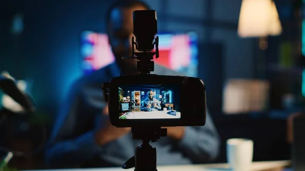 Close up shot on professional recording device in cozy home studio used for filming film video intro for online streaming platforms. Influencer in blurry background greets fanbase, focus on camera