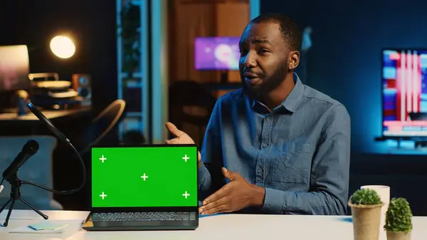 Content creator in studio films newly released green screen gaming laptop video review for tech enthusiasts. Viral online star hosts technology internet show, unboxing mockup notebook device
