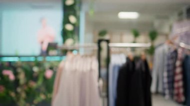 Kamera görüntüsü, yeni koleksiyonun modaya uygun kıyafetlerini sergileyen üst düzey tasarımcı sergi salonundaki askıların üzerindeki tişörtlerden oluşan şık bir seçimle seyahat ediyor. Erkek kıyafetleriyle dolu alışveriş merkezi moda koridorları.