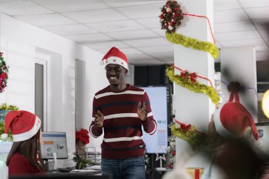 Çok ırklı iş adamları tatil tatilinin tadını çıkarıyorlar, bayram sezonunda festival dekorasyonlu yönetim kurulunda birlikte gülüyorlar. Çalışanlar Noel ruhunu hissediyorlar, Xmas süsleme ofisinde eğleniyorlar.