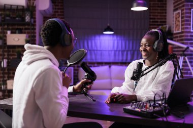 Çevrimiçi şov sunucusu, komedi odaklı podcast sırasında Afro-Amerikan komedyenlerle şakalaşmayı seviyor. RGB ışıklarıyla donatılmış oturma odasından canlı yayın yapan röportajcı.