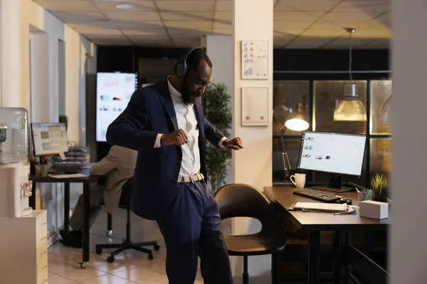 深夜穿着手机在新创公司听音乐是一项积极的业务 非洲裔美国商人在完成财务报告后跳舞和玩乐 业务概念 — 图库照片