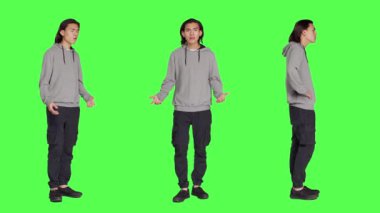 Stüdyoda hiçbir sembol göstermeyen genç, izole edilmiş yeşil perde arkaplanı üzerinde olumsuzluk ve anlaşmazlığı ifade ediyor. Asyalı bir erkek hayal kırıklığına uğruyor ve bir şeyi onaylamıyor..