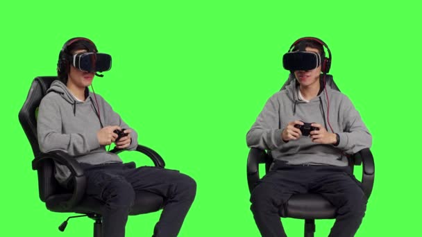 亚洲玩家用Vr耳机和操纵杆玩电子游戏 玩现代设备 年轻成年人坐在绿屏的背景下 享受网上游戏的挑战 — 图库视频影像
