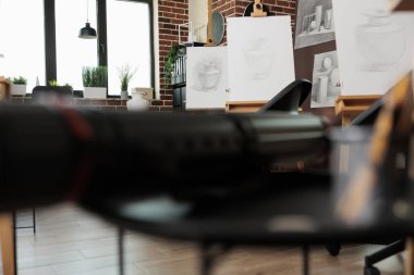 Yetişkin sanat dersleri ve atölyeler. Öğrencileri, güzel sanatlar akademisini, çizim ve çizim kurslarını, çağdaş resim stüdyosunun içini bekleyen ahşap sehpaları olan modern yaratıcı stüdyo alanı.