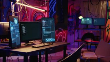 Bilgisayar ekranlarında kötü amaçlı yazılım geliştirme kodları var. Yeraltı sığınağında duvarlara grafiti yapılmış. Neon ışıklı yerdeki siber suç faaliyetlerinde kullanılan bilgisayar sistemi ekipmanları