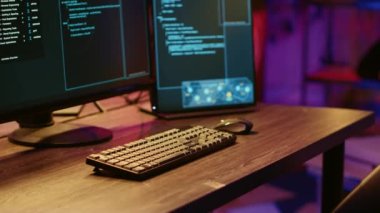 Bilgisayar ekranlarındaki kötü niyetli hackleme geliştirici kodunu gösteren yazılım arayüzünün yakın çekim görüntüsü. Boş suçluların ininde duvarlara grafiti püskürtülmüş kötü amaçlı yazılım programlama sistemleri aktif.