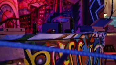 Boş sprey kutuları ve dağınık terk edilmiş depoda duvarlarına grafiti püskürtülmüş pizza kutularının görüntüsü. Arkaplan bilgisayarlarında çalışan Hacking yazılımının olduğu harabe şehir sığınağı