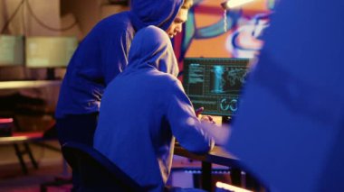 Grubun kurucusunu hacklemek yeni üyesini başlatıyor, ona güvenlik duvarlarını nasıl yok edeceğini ve sığınaktaki bilgisayarlara nasıl virüs bulaştıracağını gösteriyor. Kötü siber güvenlik gurusu senarist çocuğa kötü amaçlı yazılım kodunun nasıl yazılacağını öğretiyor.