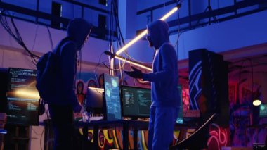 Kapüşonlu suçlu hackleme grubunun yeni üyesini karşılıyor, ona gizli yeraltı üssünü gezdiriyor ve yaptıkları işleri anlatıyor. Hacker, meslektaşına gizli bir merkez turu yapıyor.