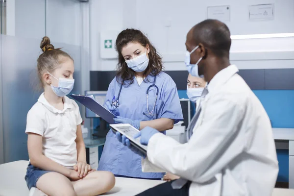 Enfermeira Bata Azul Preenchendo Uma Prancheta Com Informações Sobre Menina — Fotografia de Stock