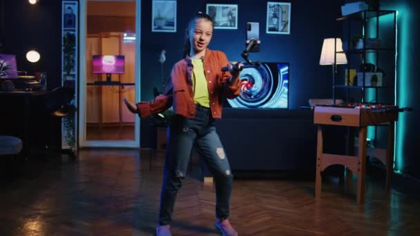潘宁拍摄的年轻媒体明星在公寓里跳舞的镜头 用手机为互联网粉丝录制的视频 兴奋的孩子用手机拍摄自己跳舞的动作 — 图库视频影像