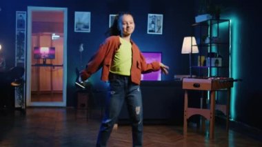 Genç bir çocuk neon ışıklı ev stüdyosunda inanılmaz dans figürleriyle takipçilerini büyülüyor. Yetenekli kız sosyal medya platformlarında havalı dans yetenekleri sergiliyor, aile dostu içeriği filme çekiyor.