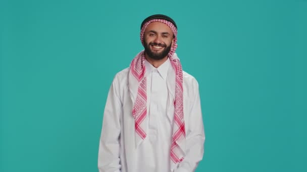 スタジオで撃たれたイスラム教徒の男がイエスと言い 承認を表明した 伝統的な服を着たアラブ人は 何かを支持している 中東の男性がポジティブで合意サイン — ストック動画
