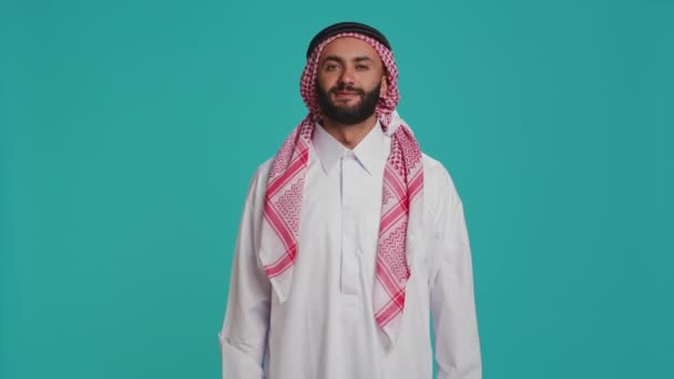 Άτομο Που Φοράει Συνηθισμένα Thobe Και Kufiyah Φαίνεται Χαρούμενο Επιδεικνύοντας — Αρχείο Βίντεο