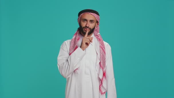 アラブ人男性は唇の上に指で沈黙のサインをし スタジオでホシュミュートジェスチャーを示しています カメラに秘密の秘密のシンボルを提示するプライベートモデルは 秘密とプライバシーを保持しようとしています — ストック動画