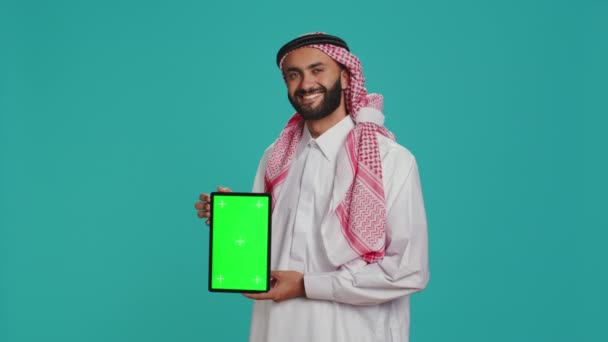 Osoba Arabska Pokazuje Zielony Ekran Nad Tłem Studia Prezentując Odizolowany — Wideo stockowe
