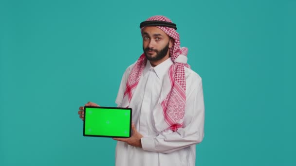 Muzułmanin Prezentuje Zieloną Tabliczkę Niebieskim Tle Pokazując Pusty Wyświetlacz Copyspace — Wideo stockowe