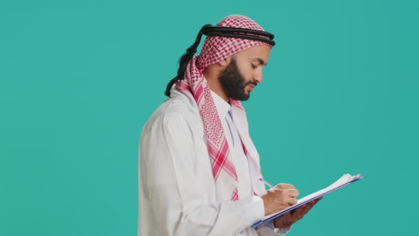 Hombre Árabe Escribiendo Carta Papeles Pie Sobre Fondo Azul Creando — Vídeo de stock