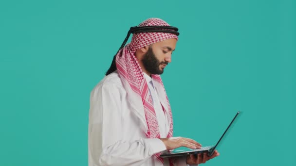Pessoa Usando Touchpad Laptop Estúdio Vestida Com Tradicional Thobe Muçulmano — Vídeo de Stock
