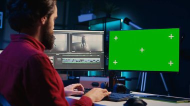 Yaratıcı ofiste renk derecelendirme ve ışıklandırma düzenlemesinden önce izole ekran ekranında film montajını analiz eden video editörü. Yapım stüdyosu çalışanı Chroma Key PC 'de ham görüntülerle çalışıyor