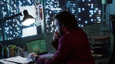 Gece vakti lüks çalışma ortamında, baş mali danışman alternatif istihdam olanakları için para yatırımı konusundaki dünya genelindeki eğilimleri araştırıyor. Zengin girişimciler tarafından incelenen materyaller.