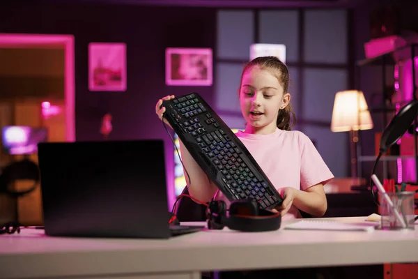 stock image Happy child reviewing mechanical keyboard received from sponsoring brand to promote it. Young media star advertising wireless Bluetooth computer peripheral from partnering company