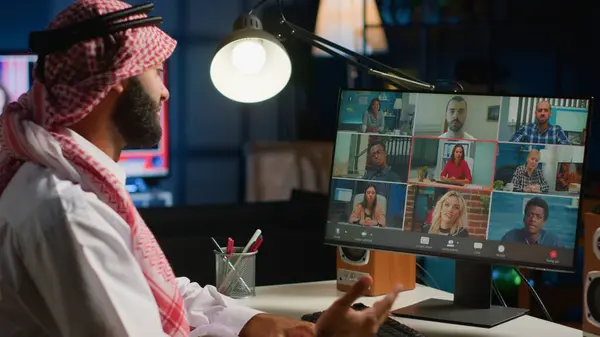 Arab man paying attention in webinar internet teleconference. Middle Eastern student in online videocall with tutor and other diverse multiethnic colleagues, listening to lesson