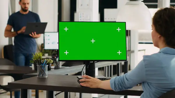 Startup manager using greenscreen display on computer at workstation, checking modern network with isolated copyspace template. Businesswoman working with mockup chromakey screen.