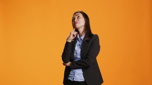 Tankeväckande Affärskvinna Poserar Över Orange Bakgrund Tänker Nya Idéer Och — Stockvideo