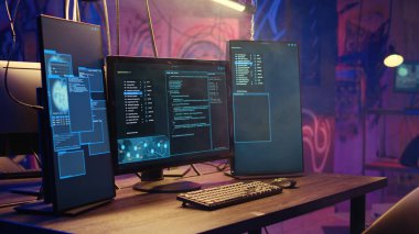 Bilgisayar ekranındaki yazılım arayüzüne yakınlaştır. Boş bir depoda çalışan programlama kodunu ve duvarlara grafiti püskürtülmüş halini göster. Yeraltı üssündeki monitörlerde ikili dil