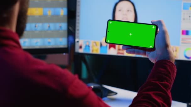 图片编辑器使用绿色屏幕手机观看教程 在创意工作室学习正确的图片颜色 摄影师在彩色键智能手机上观看导引视频 — 图库视频影像
