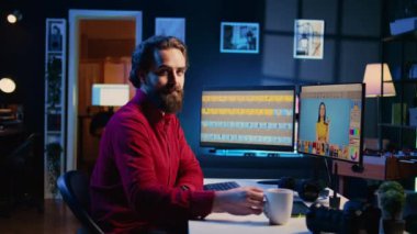 Mutlu fotoğraf editörünün portresi resim düzenleme, post prodüksiyon şirketinde renk düzeltmesi yapma ve kahvenin tadını çıkarma. Gülümseyen fotoğrafçı aşırı pozlanmış resimleri rötuşlama yazılımıyla düzeltiyor, yakınlaştırıyor