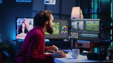 Video editörü İHA çekimlerinin bölümlerini kırpıyor, yaratıcı ofiste promosyon klibi projesi üzerinde çalışıyor. Videograf film parçalarını birleştiriyor, bilgisayar üzerinde profesyonel yazılım kullanarak düzenliyor