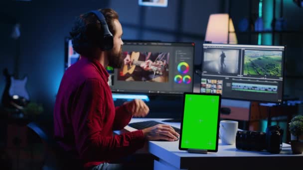 视频编辑器为电影镜头添加音效 在后期制作工作室使用绿色屏幕平板电脑 录像师使用耳机来测试和提高模拟设备旁边的音频质量 — 图库视频影像