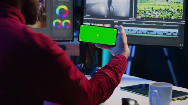 视频编辑器观看了关于在创意办公室编辑色彩分级和照明的模拟电话教程 工作室员工学习如何使用绿色屏幕智能手机的原始视频 — 图库视频影像