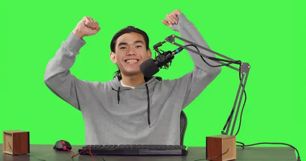 POV of content creator on live stream recording gameplay of new action video game launched, greenscreen backdrop. Asian streamer broadcasting multiplayer competition, streaming with microphone.