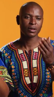 Dikey Video Etnik çift kameranın önünde hava öpücüğü veriyor, stüdyoda romantik flörtler yapıyor ve aşkı paylaşıyorlar. Afrikalı Amerikalı evli insanlar birine öpücük yolluyor, sevgi sembolü..