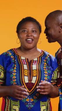 Dikey Görüntü Etnik Adam kamerada kız arkadaşına eğilip sırrını anlatıyor, önemli gizli bilgileri veriyor ve gizlilik ya da gizliliği koruyor. Afrikalı Amerikalı çift eğleniyor.