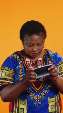 Dikey Video Mutlu Adam video oyunlarını kutluyor kamerada kazanıyor, kız arkadaşıyla cep telefonu oyun yarışması yapıyor. Kocası kazanırken etnik kadın yarışmayı kaybediyor, stüdyo çekimi..