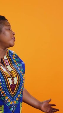 Dikey Video Romantik Adam karısına kurdele verip selam vererek doğum gününü ya da yıldönümlerini kutlamak için hediye kutusu veriyor. Afrikalı Amerikalı bir kadın tatlı paketlenmiş hediye alıyor.