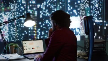 Geceleri gökdelen ofis binasında çalışan yönetici, yeni kariyer fırsatları için küresel yatırım eğilimlerini inceliyor. Milyarder vizyonu olan nüfuzlu işadamı raporları kontrol ediyor.