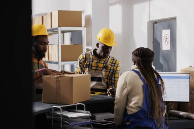 Teslimattan önce paketlenmiş paketleri inceleyen posta memuru. Depo yöneticileri ve operatör bilgisayarda istemci sipariş listesini gönderme ve kontrol etme paketini yönetiyor