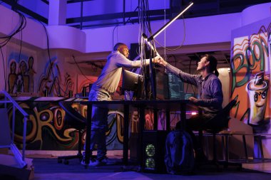 Terk edilmiş depoda yasadışı kötü niyetli yazılım kodlarken iki korsan yumruk tokuşturuyor. İnternet suçluları birlikte sunucuya girmeden önce dostane ve selamlayıcı bir jest yapıyorlar.