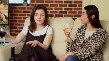 Asyalı bir kadın, apartman partisinde rahat bir koltukta arkadaşıyla sohbet ediyor şarap içiyor ve sohbetten zevk alıyor. Neşeli kankalar birbirlerini evde yakalar, şampanya içerler.